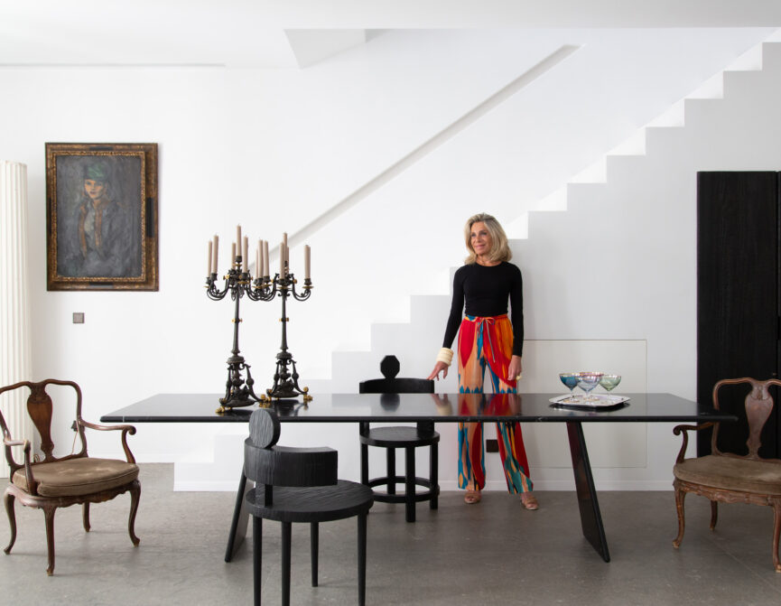 Woman stands next to a grand dining table in an Ibizan townhouse